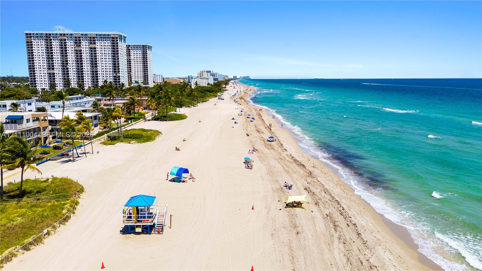 Sandy coastal shoreline featuring direct ocean access, expansive beach frontage, and mature tropical landscaping