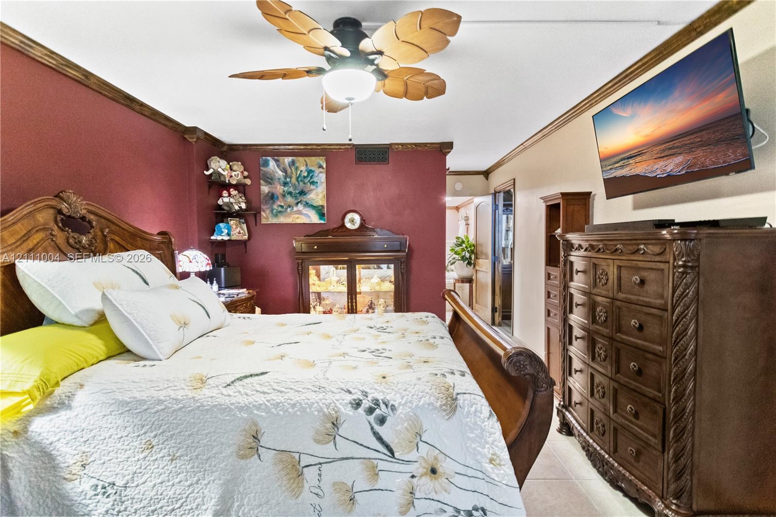 Ceiling fan with palm-leaf style blades, crown molding, and tiled flooring