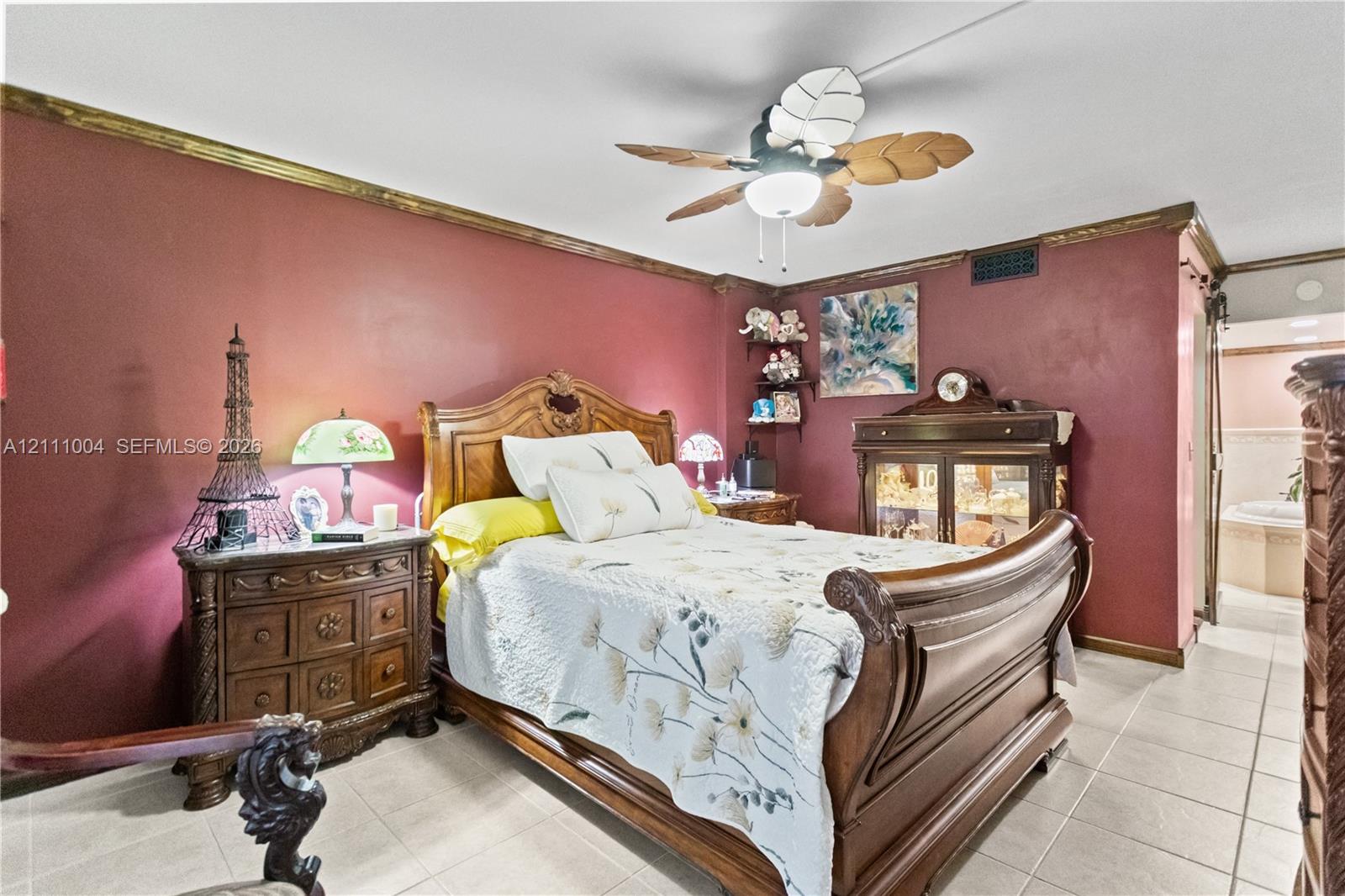 Room featuring tile flooring, crown molding, and a ceiling fan with integrated lighting