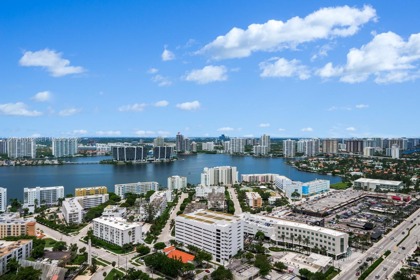 Aerial perspective featuring a panoramic expanse of waterfront and urban landscape