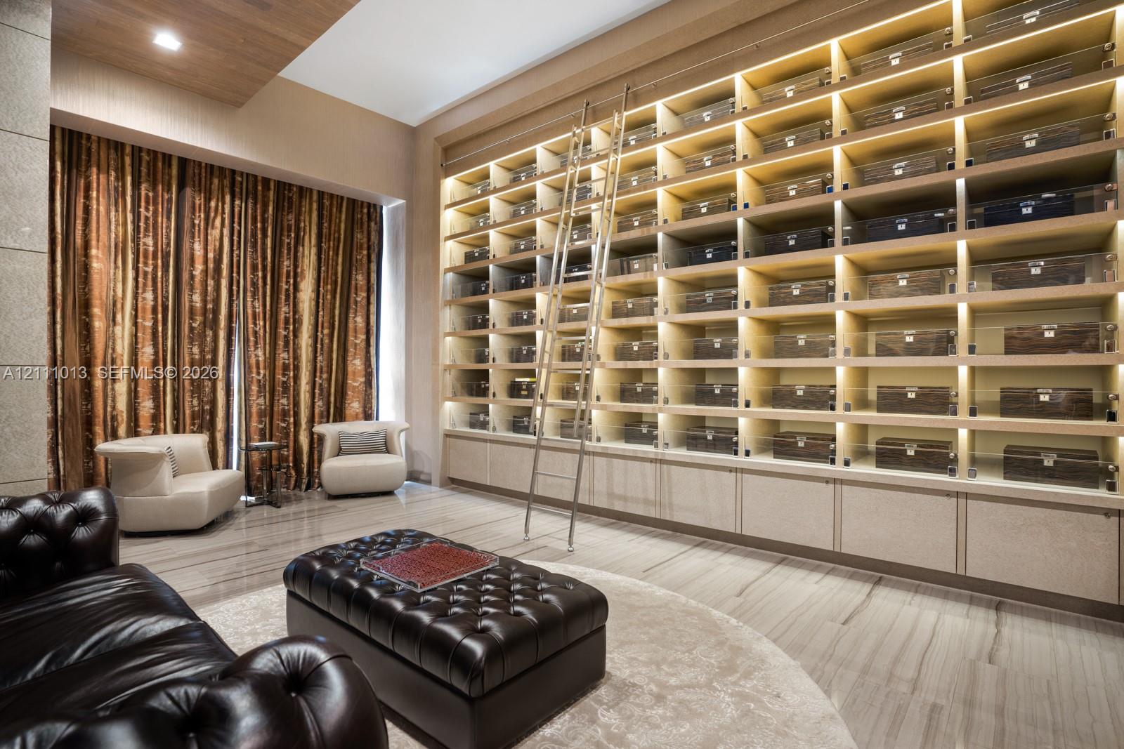Floor-to-ceiling built-in shelving featuring integrated lighting, a sliding metal library ladder, smooth stone-finish flooring, and recessed ceiling lighting