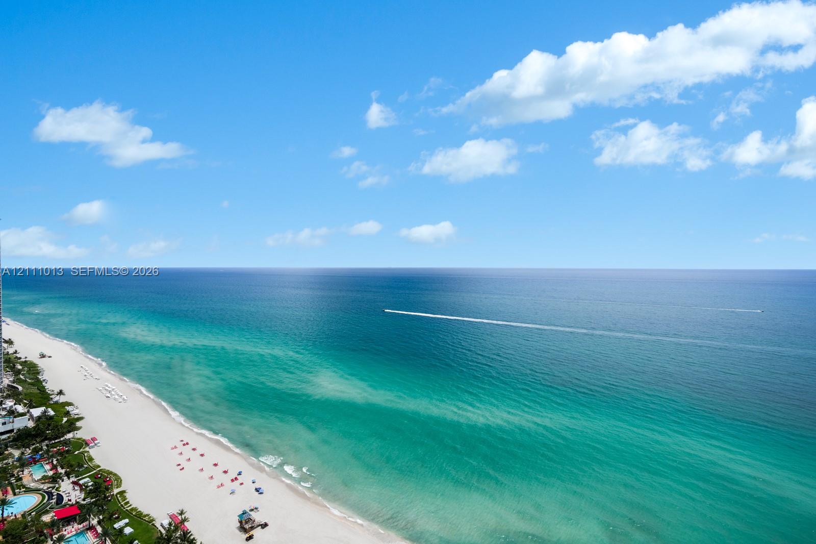 Direct oceanfront positioning featuring a sandy shoreline and expansive horizon