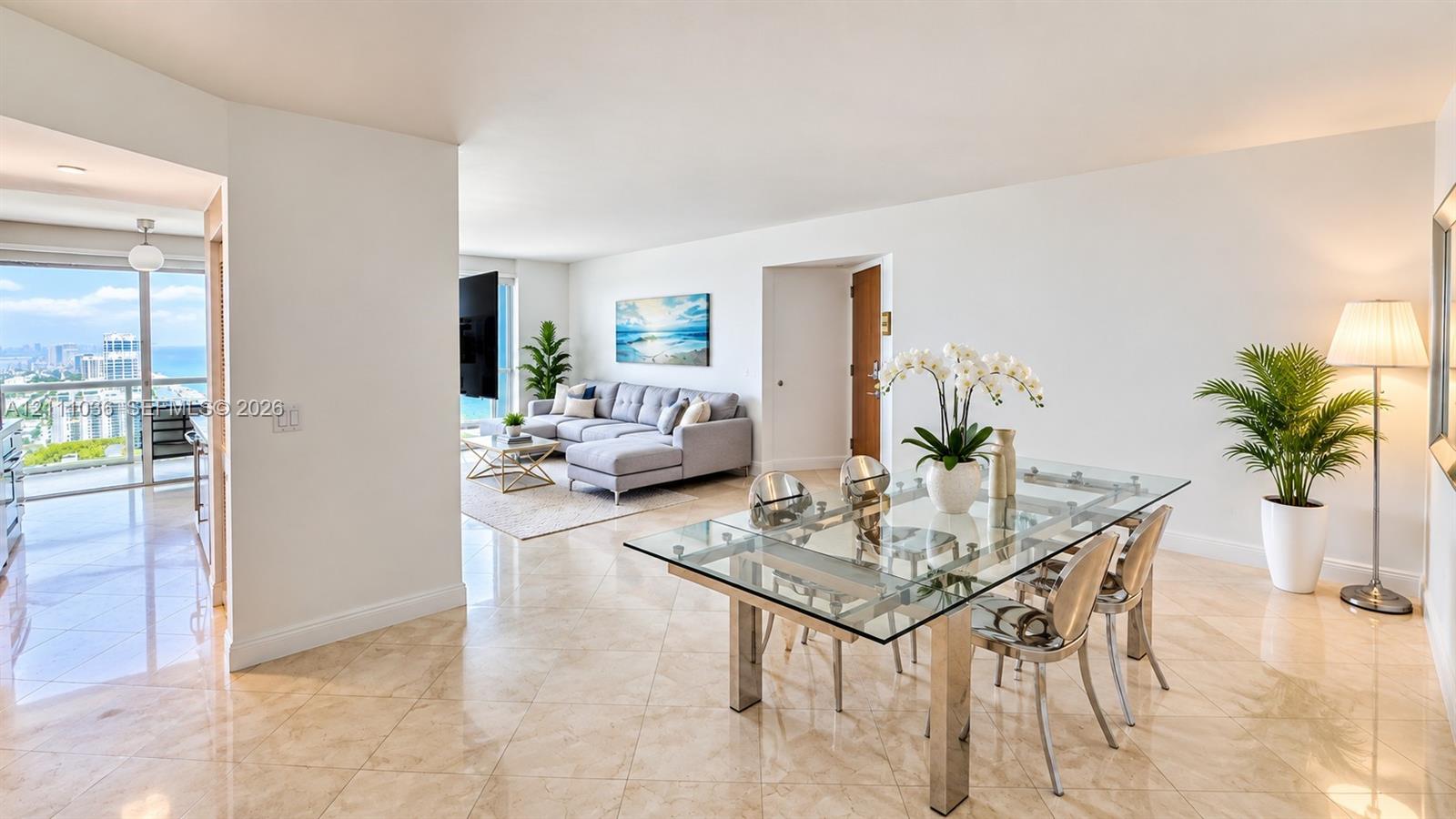 Open-concept living space featuring polished tile flooring, floor-to-ceiling glass sliding doors, and a private balcony