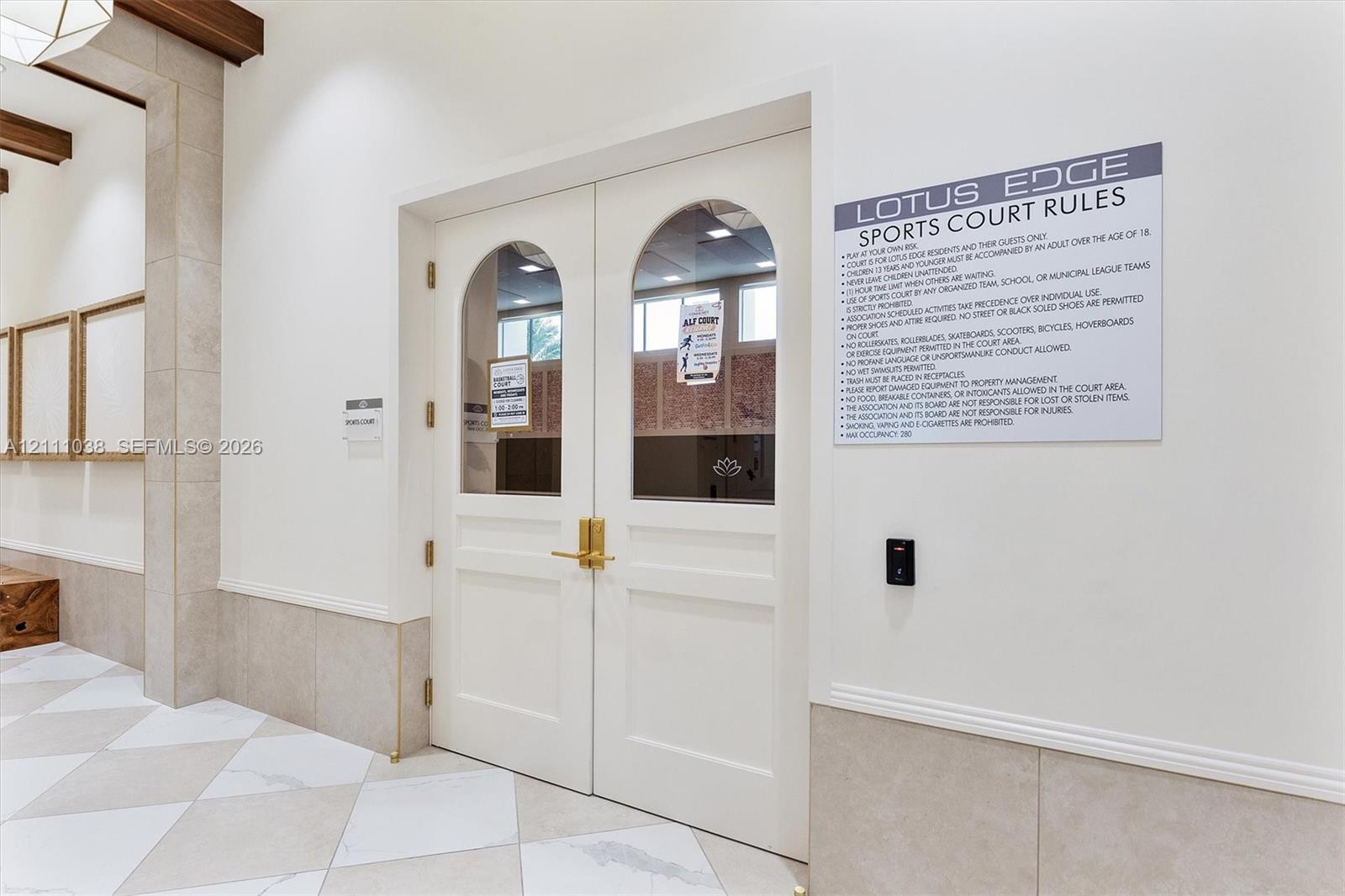Double doors featuring arched glass panels, brass hardware, and electronic keyless entry