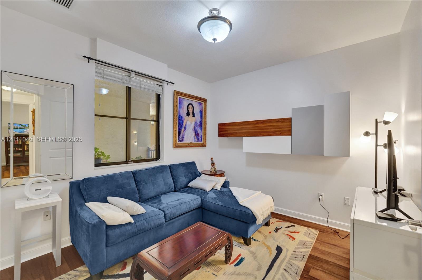 Wall-mounted contemporary cabinetry with wood-finish and matte-finish panels, flush-mount lighting, and wood-finish flooring