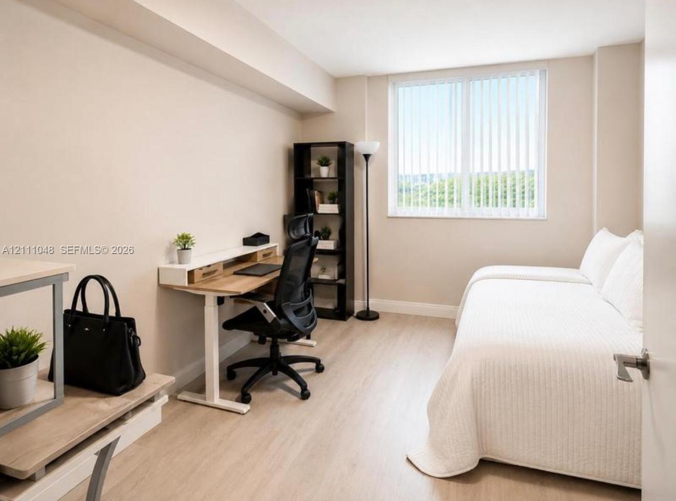 Neutral-toned room featuring wood-finish flooring, a large window with vertical blinds, and a smooth wall finish Neutral-toned room featuring wood-finish flooring, a large window with vertical blinds, and a smooth wall finish