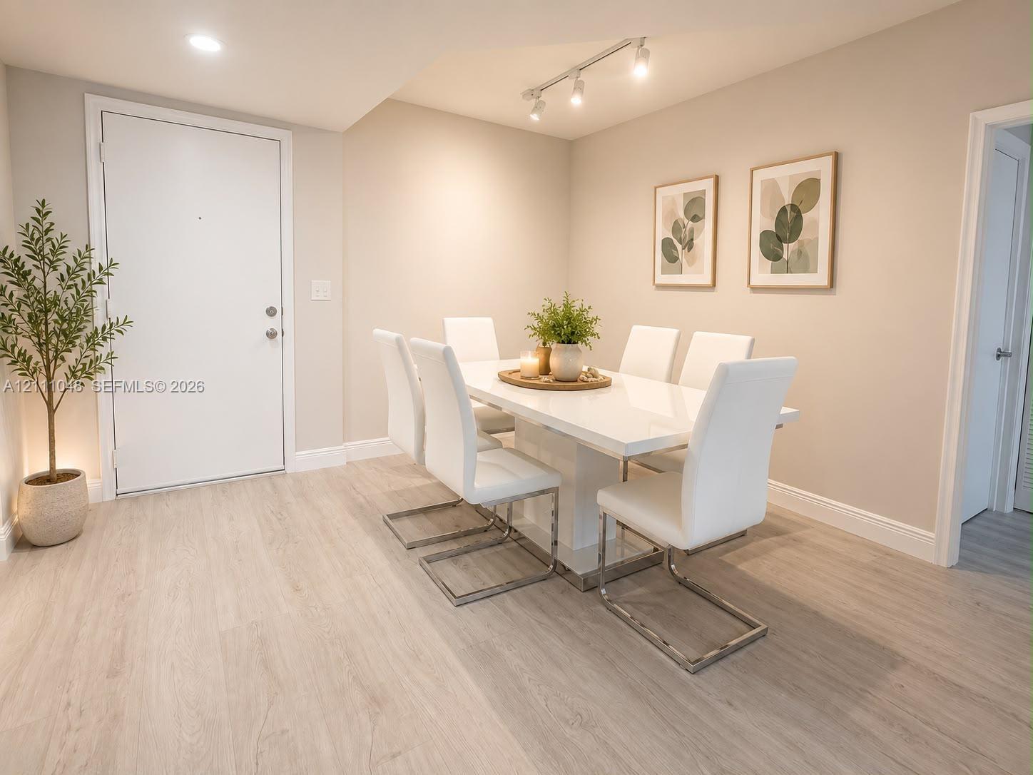 Neutral-toned interior featuring wood-finish flooring, recessed lighting, and adjustable multi-bulb track lighting Neutral-toned interior featuring wood-finish flooring, recessed lighting, and adjustable multi-bulb track lighting