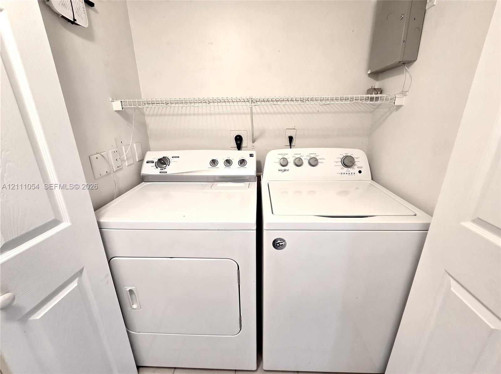 Laundry closet featuring built-in wire shelving and dual-hinged doors