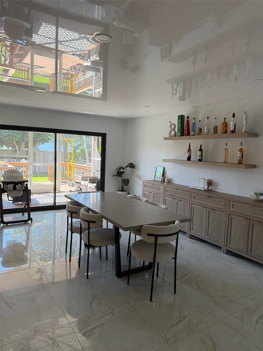 Glossy tile flooring, built-in wooden cabinetry with shaker-style doors, dual floating wood shelves, and large sliding glass doors