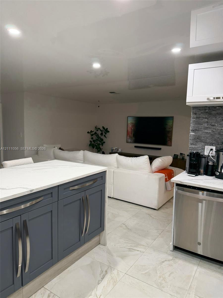 Neutral-toned interior featuring large-format tile flooring, white paneled doors, and double-door closet storage