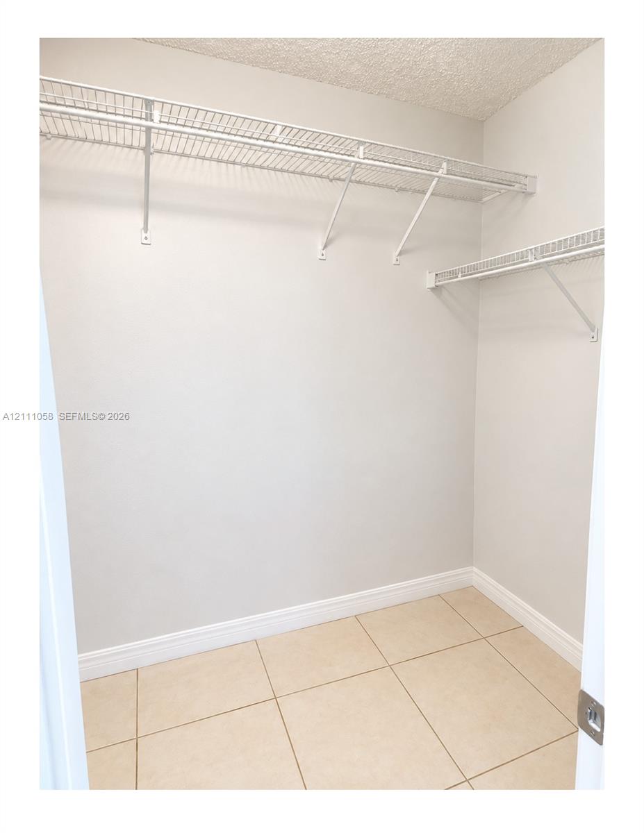 Storage area featuring ceramic tile flooring and multi-level white wire shelving Storage area featuring ceramic tile flooring and multi-level white wire shelving