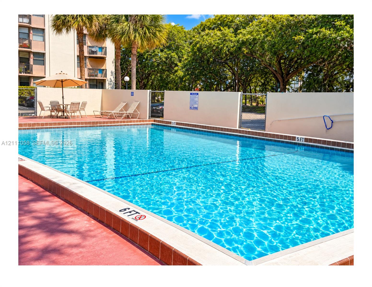 Rectangular outdoor swimming pool featuring a tiled coping, painted concrete decking, and perimeter privacy wall