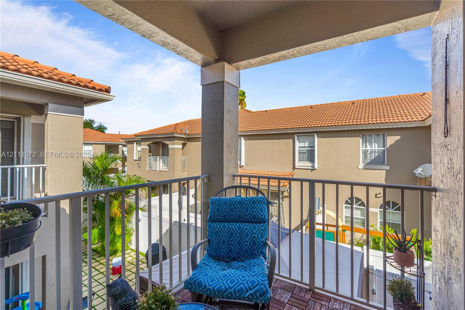 Covered balcony featuring metal railings and terra-cotta tile roofing