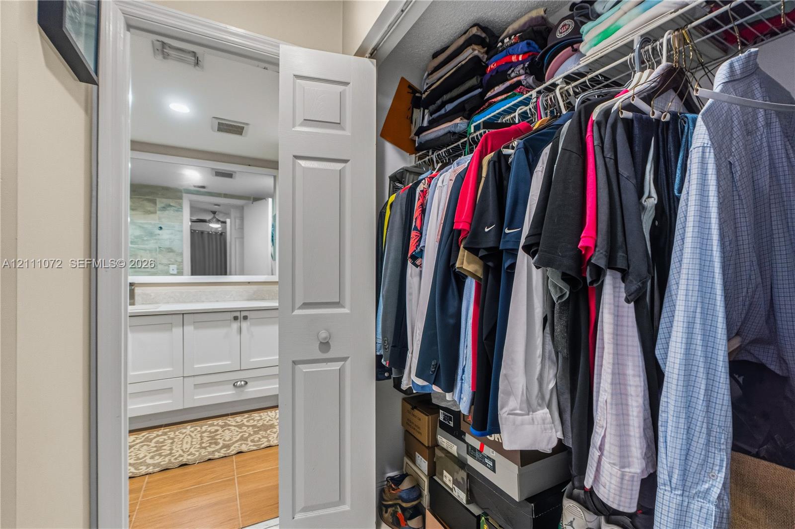Storage closet featuring wire shelving, bifold door, and tile flooring