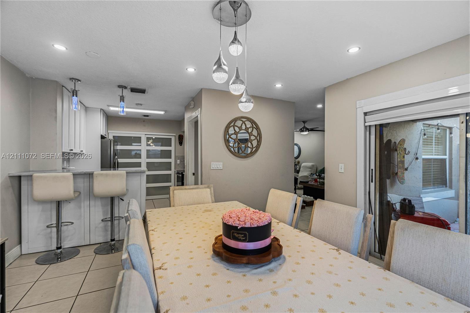 Dining area featuring recessed lighting, a modern multi-pendant light fixture, tile flooring, and sliding glass doors with access to an exterior area
