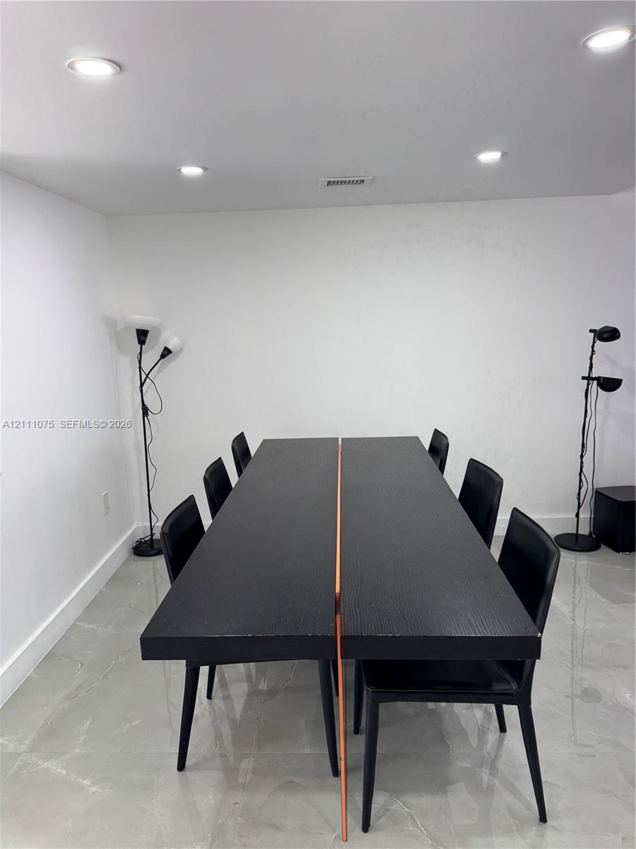 Neutral walls paired with high-gloss tile flooring and recessed overhead lighting Neutral walls paired with high-gloss tile flooring and recessed overhead lighting