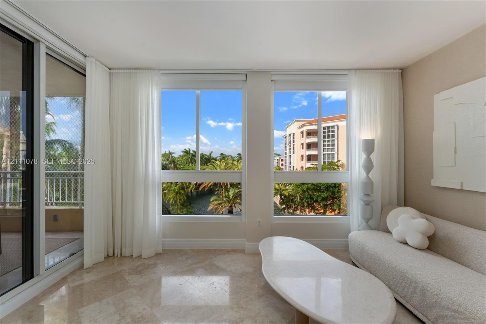 Expansive floor-to-ceiling windows featuring stone flooring and access to a screened balcony