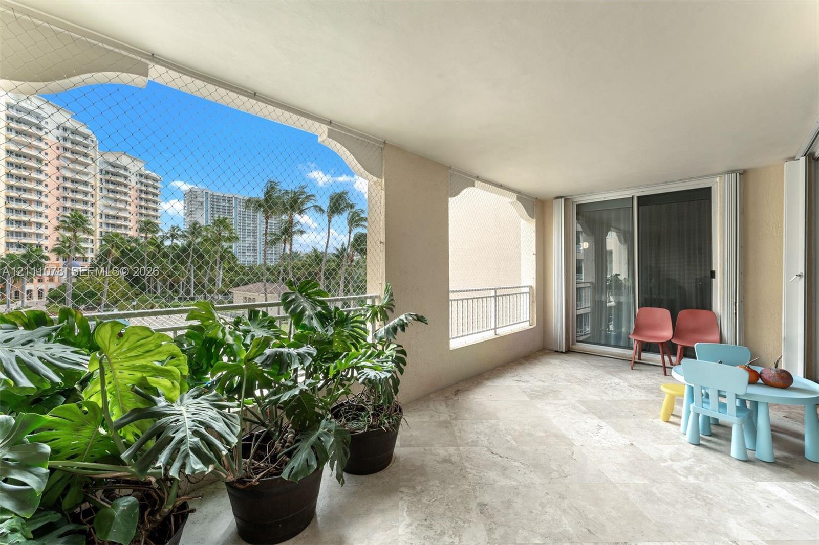 Covered balcony featuring stone flooring, integrated archway architectural detailing, and metal railings