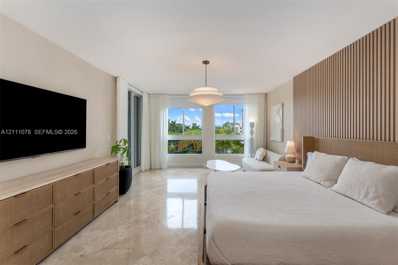 Room featuring polished stone flooring, custom vertical slat wood wall paneling, built-in drawer cabinetry, and large-scale windows