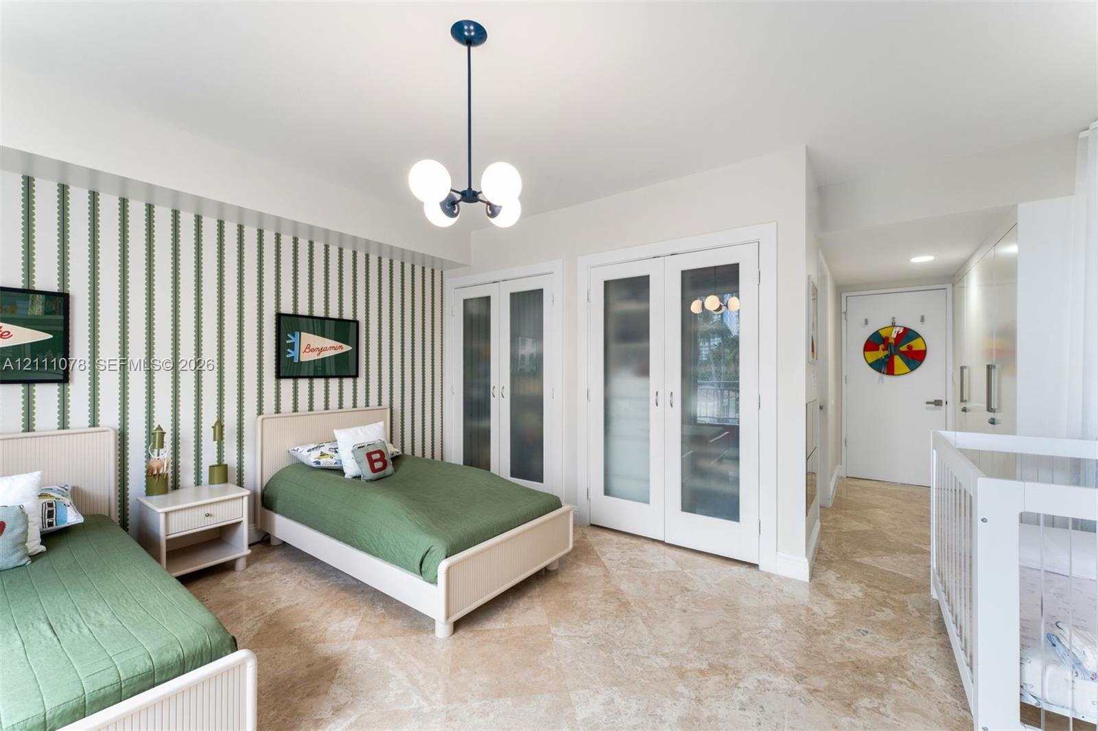 Room featuring stone tile flooring, a modern four-globe chandelier, and double doors with frosted glass panels