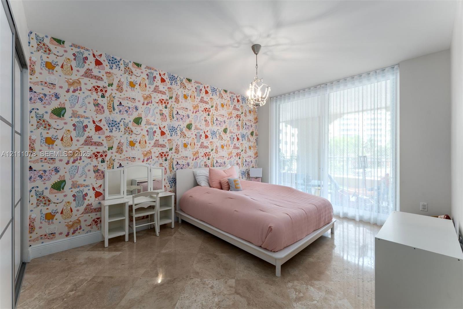 Polished stone flooring, floor-to-ceiling glass wall with sheer drapery, decorative accent wall, and multi-arm chandelier