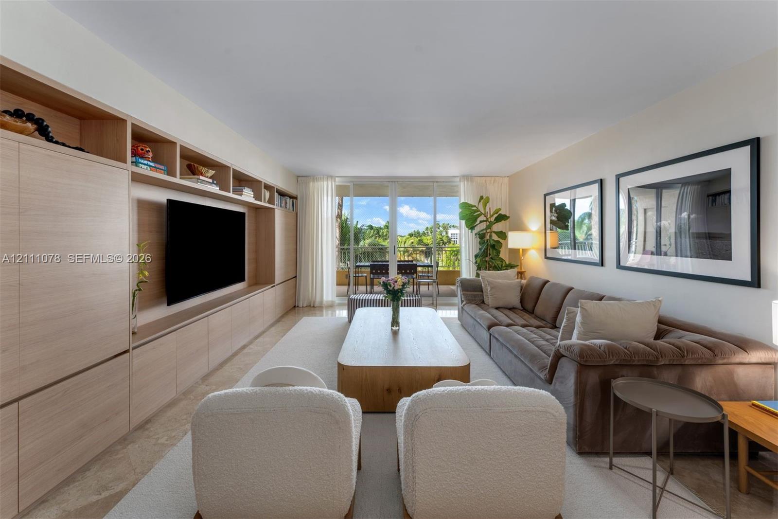 Custom full-wall wood-finish built-in cabinetry, sliding glass doors, neutral stone flooring, and recessed ceiling lighting