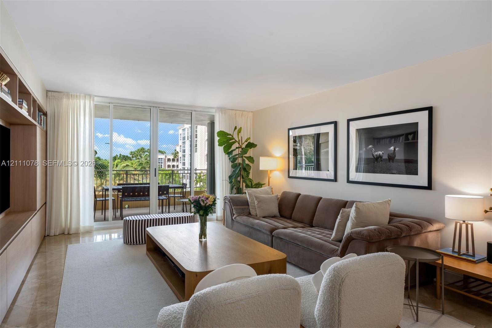 Open-concept living space featuring floor-to-ceiling glass sliding doors, stone-finish flooring, and built-in floor-to-ceiling cabinetry