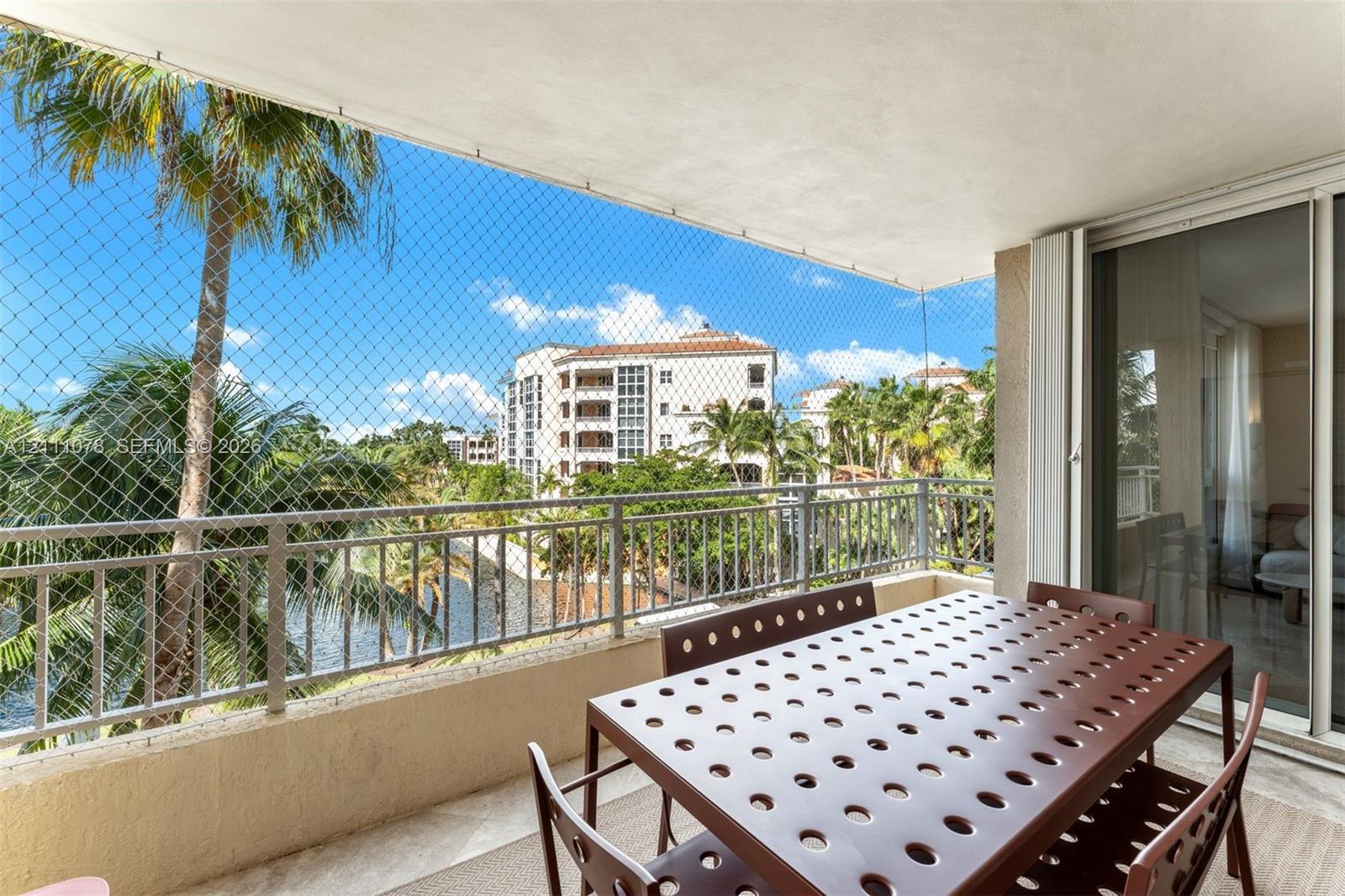 Covered balcony with metal railing, stone-finish flooring, and sliding glass entry door