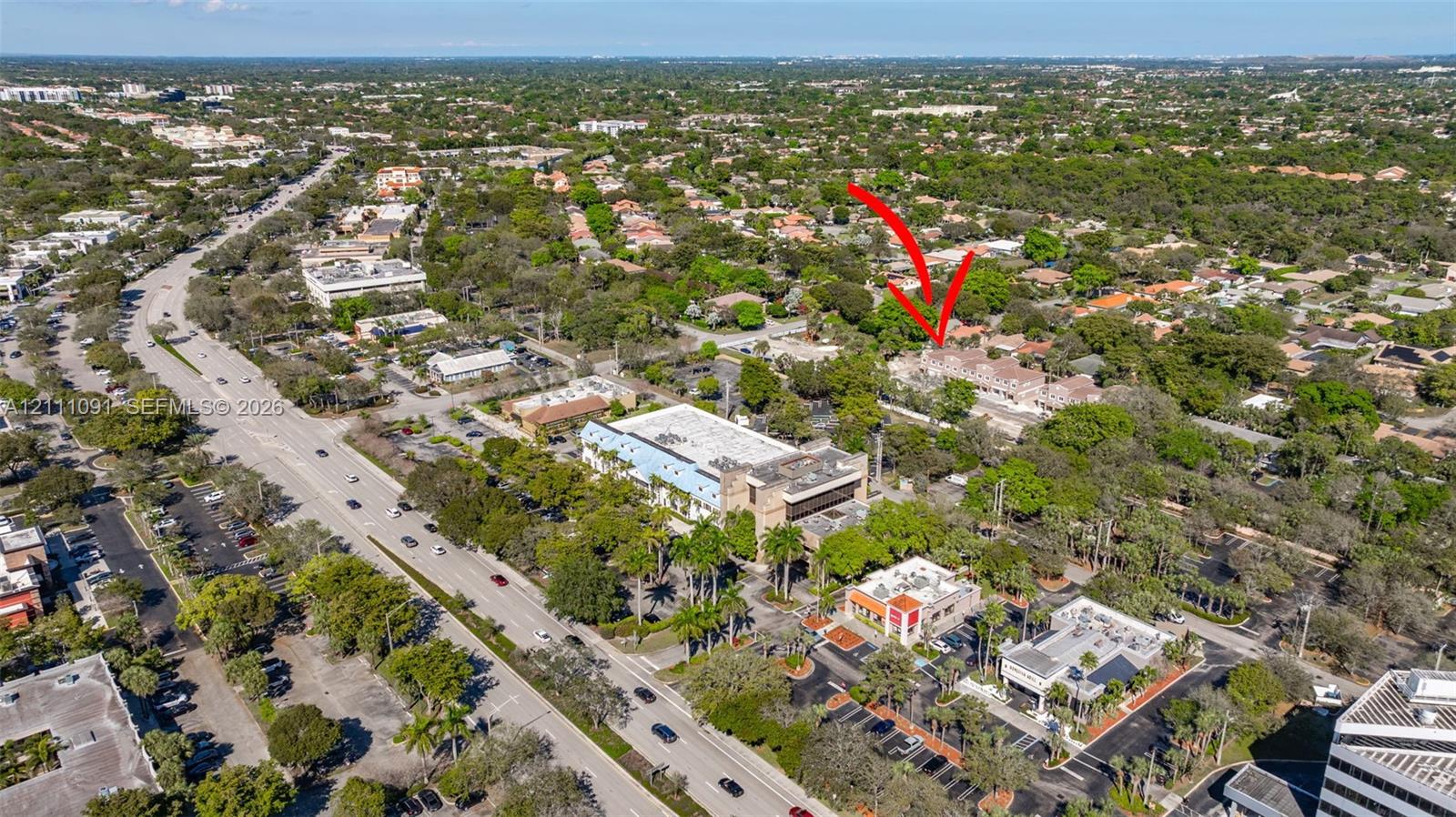 Aerial perspective of property featuring mature tree canopy, multi-level structural design, and established residential landscaping