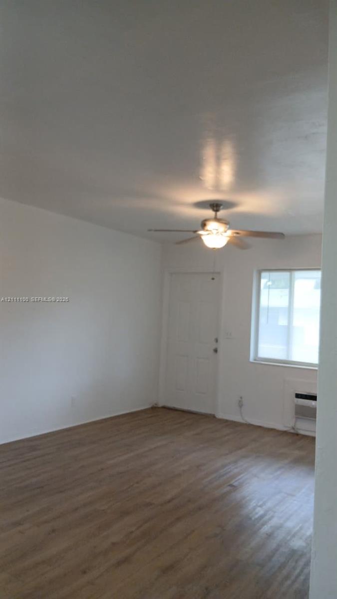 Wood-finish flooring, ceiling fan with integrated light fixture, and window with natural light Wood-finish flooring, ceiling fan with integrated light fixture, and window with natural light