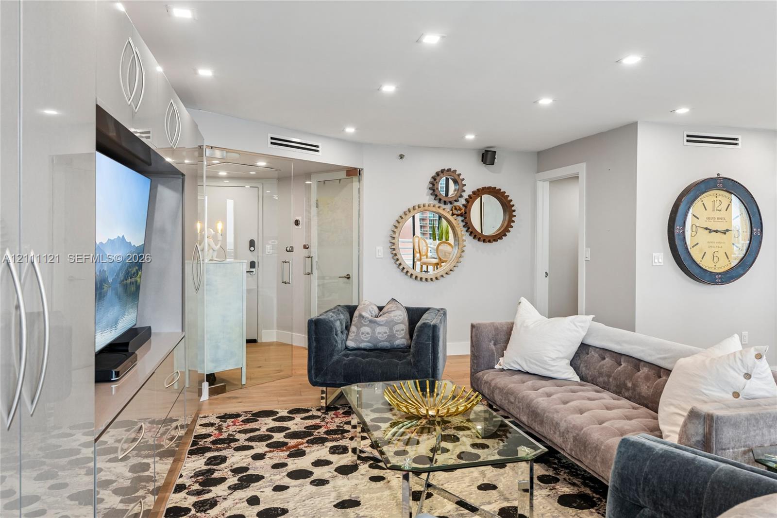 Recessed lighting, wood-finish flooring, high-gloss built-in cabinetry, and glass-paneled interior entry