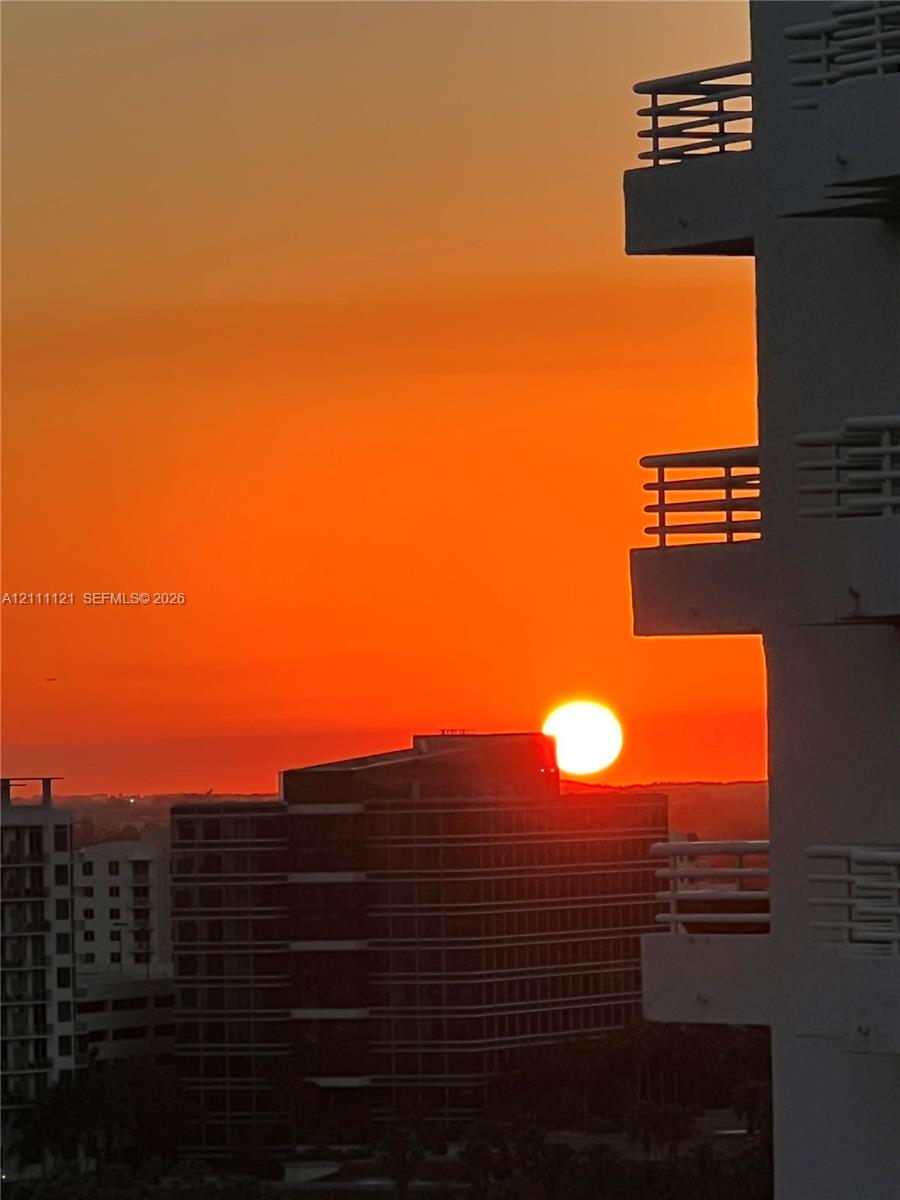 Elevated balconies with horizontal railings featuring a sunset backdrop
