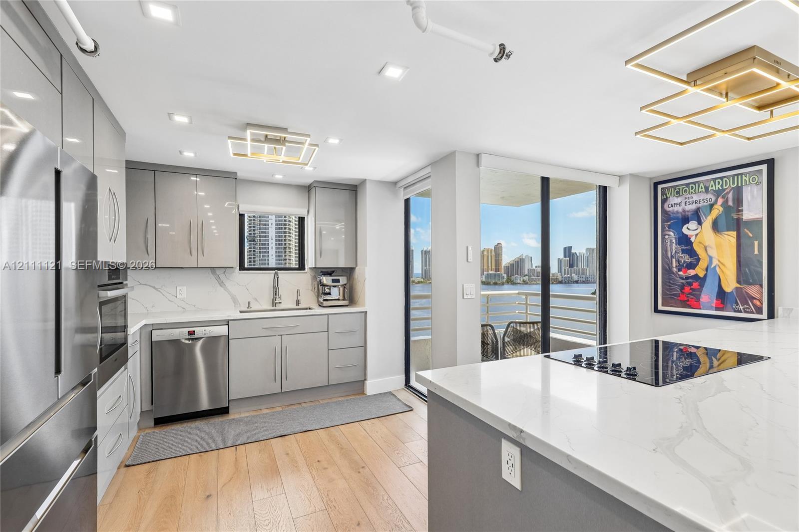 Kitchen featuring high-gloss cabinetry, stone-surface countertops, wood-finish flooring, stainless steel appliances, and integrated geometric lighting fixtures