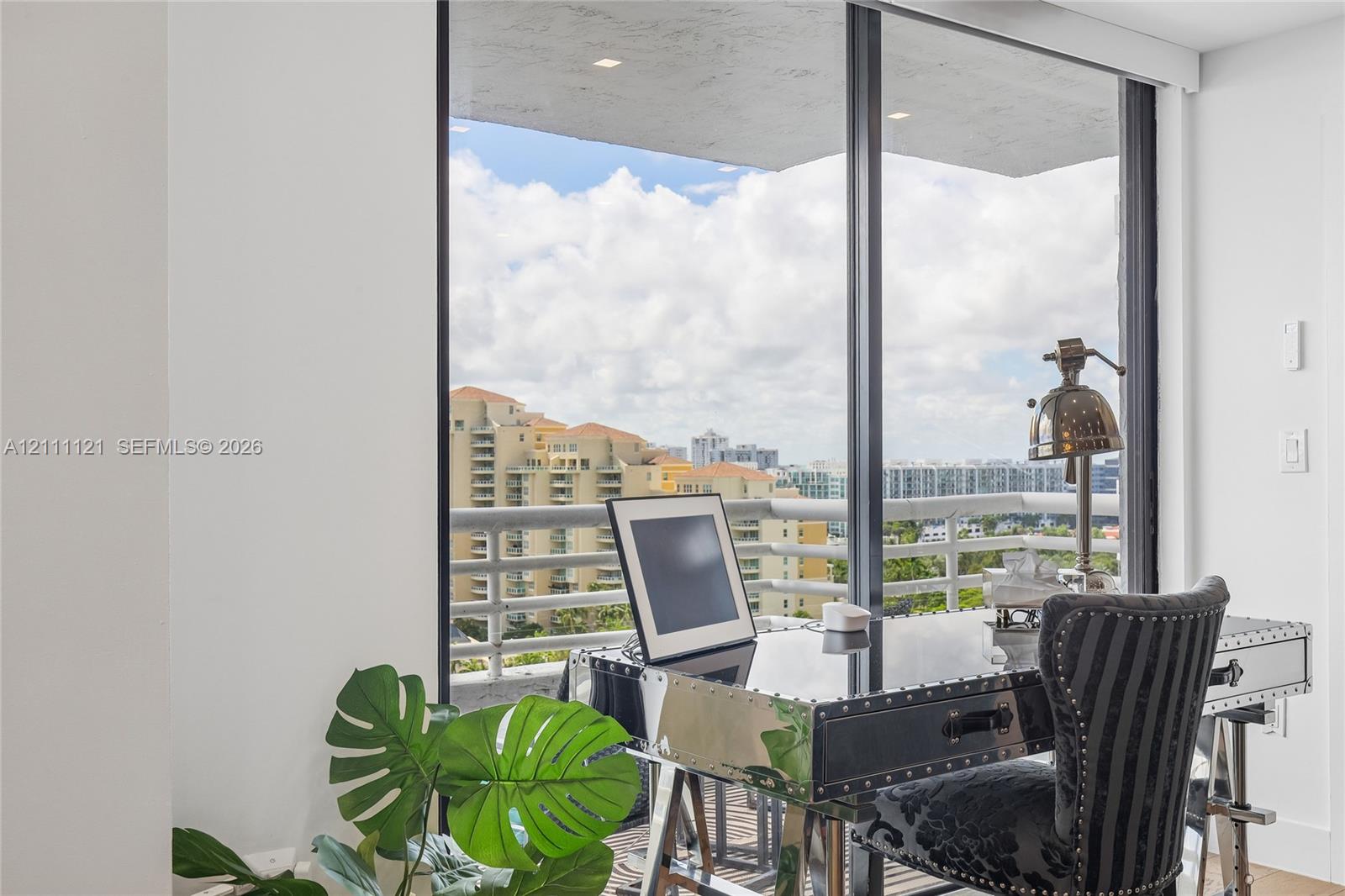 Floor-to-ceiling glass paneling featuring a metal frame and attached balcony