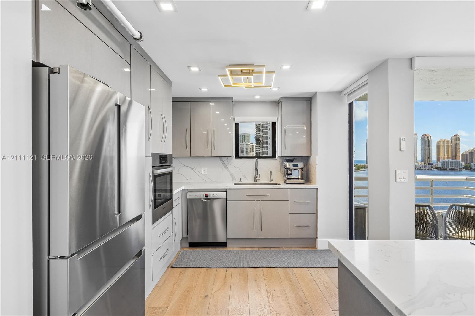 Kitchen featuring high-gloss cabinetry, stone-finish countertops with matching backsplash, stainless steel appliances, recessed ceiling lighting, and wood-finish flooring
