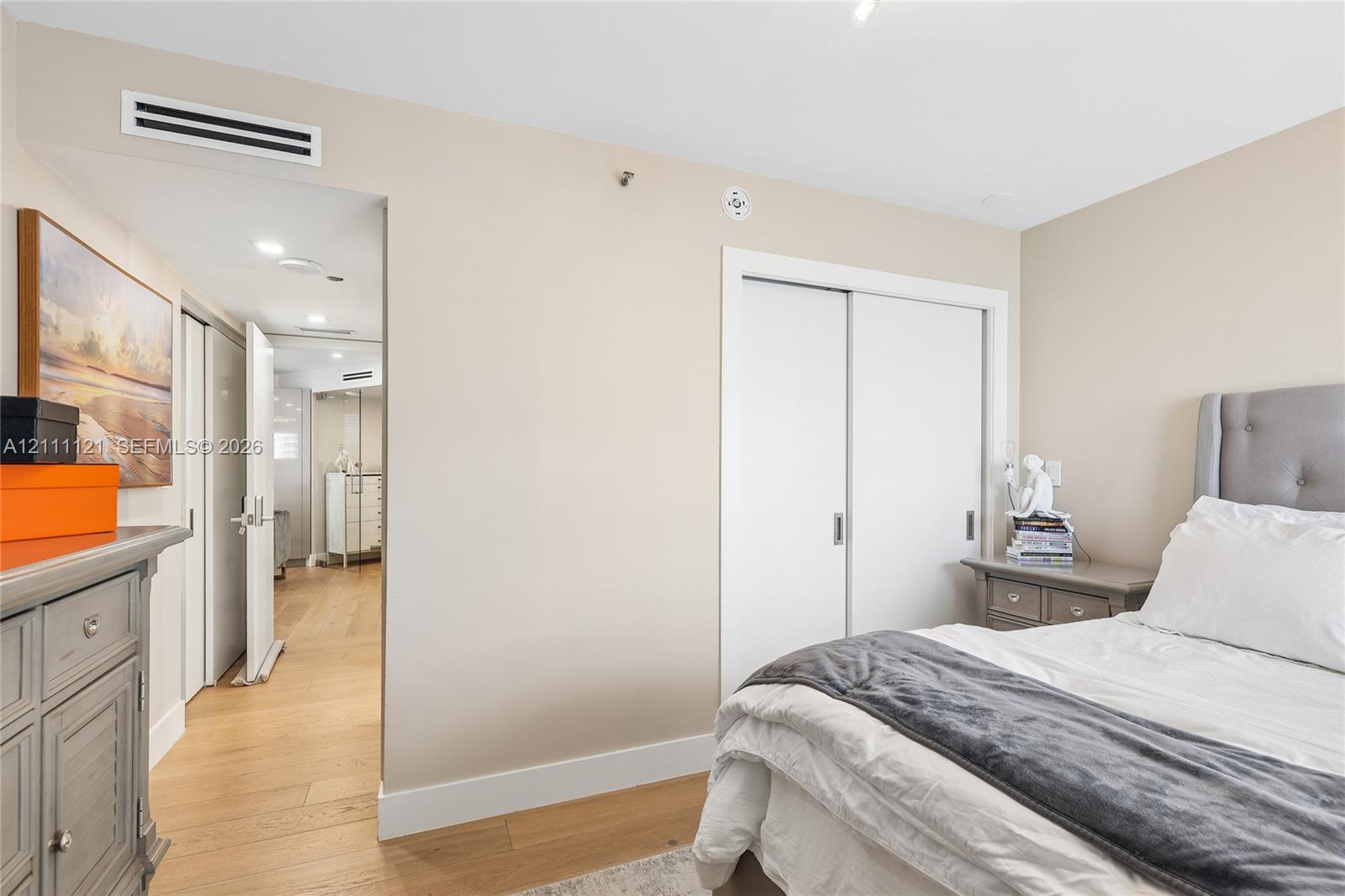 Neutral-toned interior featuring wood-finish flooring, recessed lighting, and a double-door sliding closet