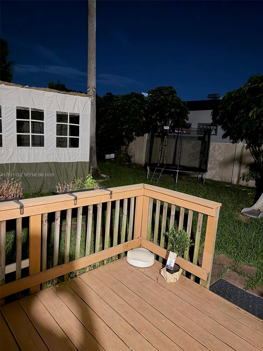 Wooden deck featuring a railing and manicured lawn area
