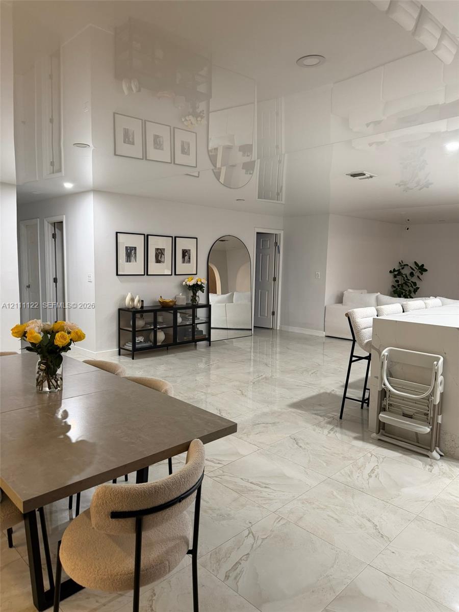 High-gloss reflective ceiling, large-format polished stone-finish floor tiling, recessed lighting, and integrated island cabinetry