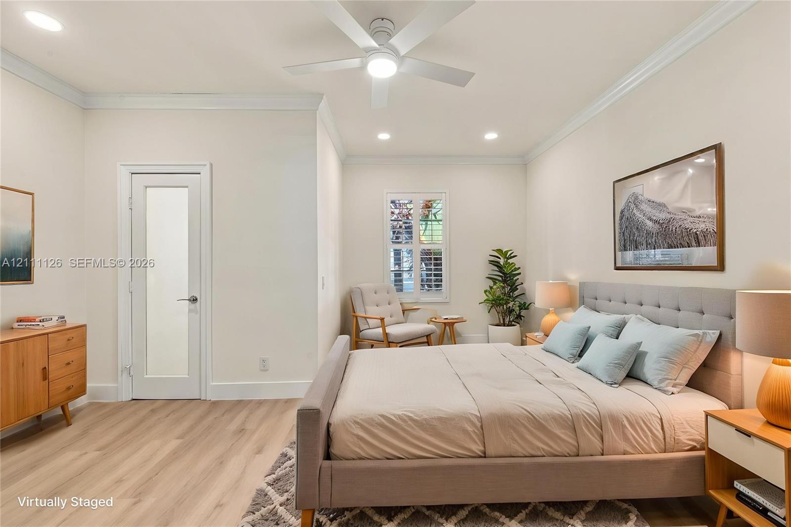 Neutral interior featuring wood-finish flooring, recessed lighting, crown molding, a ceiling fan, and a door with a frosted glass pane