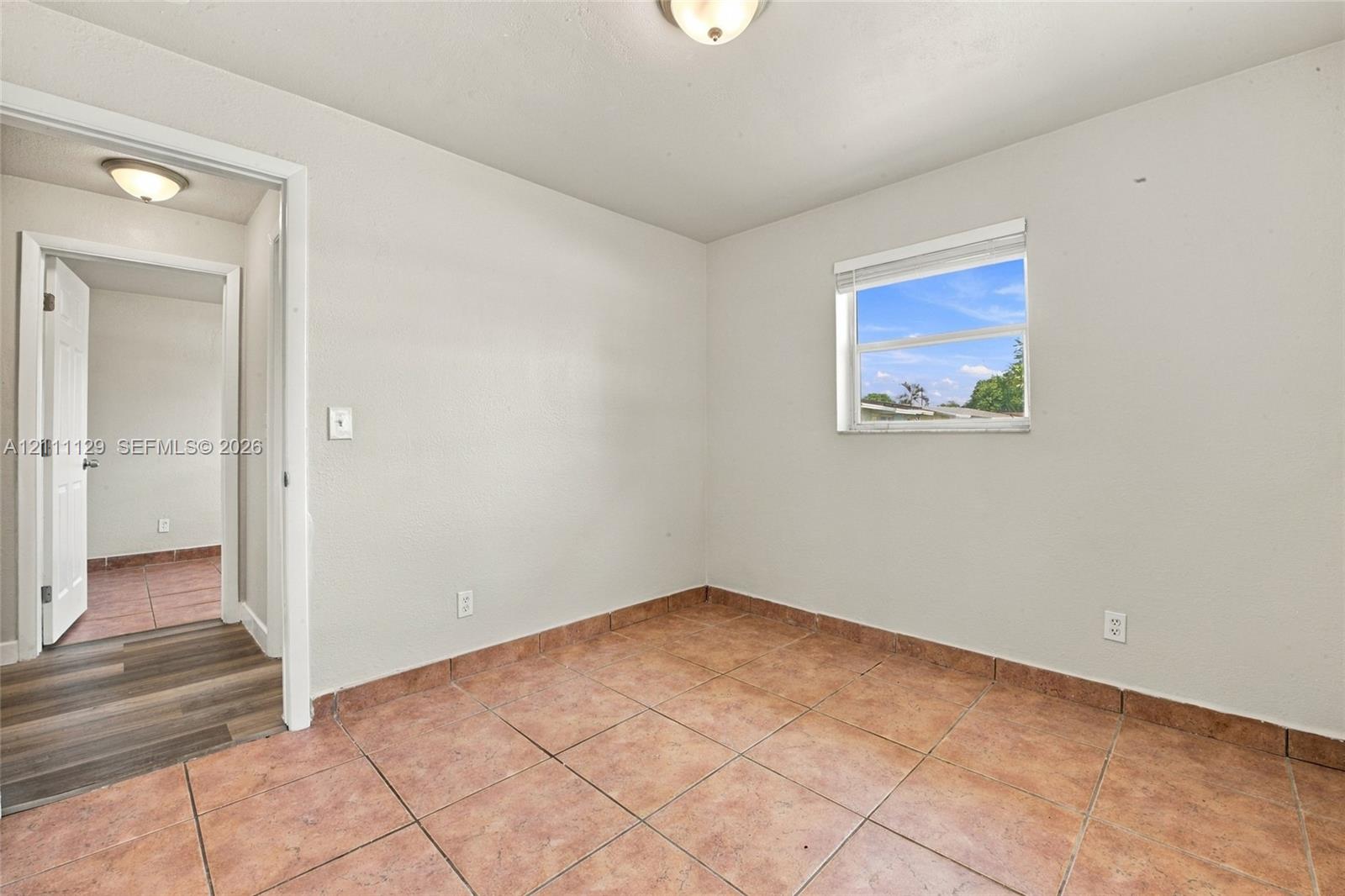 Room featuring ceramic tile flooring, neutral wall paint, and a single-pane window