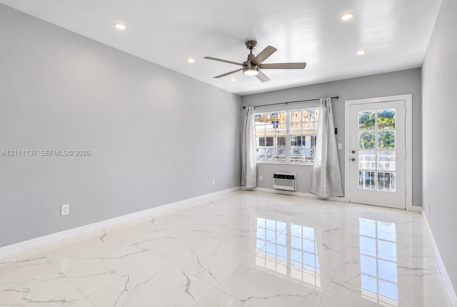 Interior space featuring large-format tile flooring with veining, recessed lighting, ceiling fan, and a multi-lite exterior door Interior space featuring large-format tile flooring with veining, recessed lighting, ceiling fan, and a multi-lite exterior door