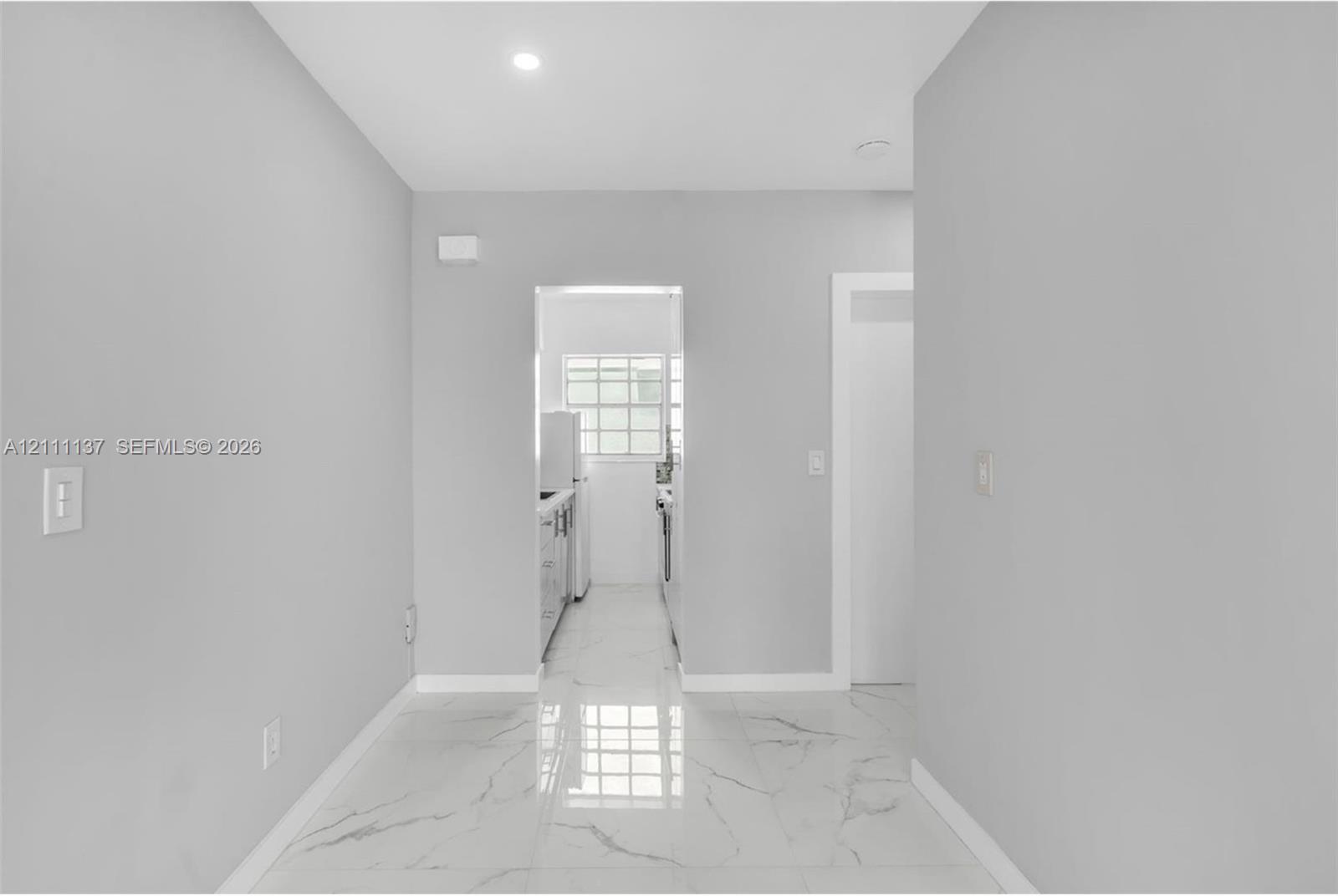 Large-format polished tile flooring with a marble-style vein pattern, neutral wall palette, and recessed lighting Large-format polished tile flooring with a marble-style vein pattern, neutral wall palette, and recessed lighting