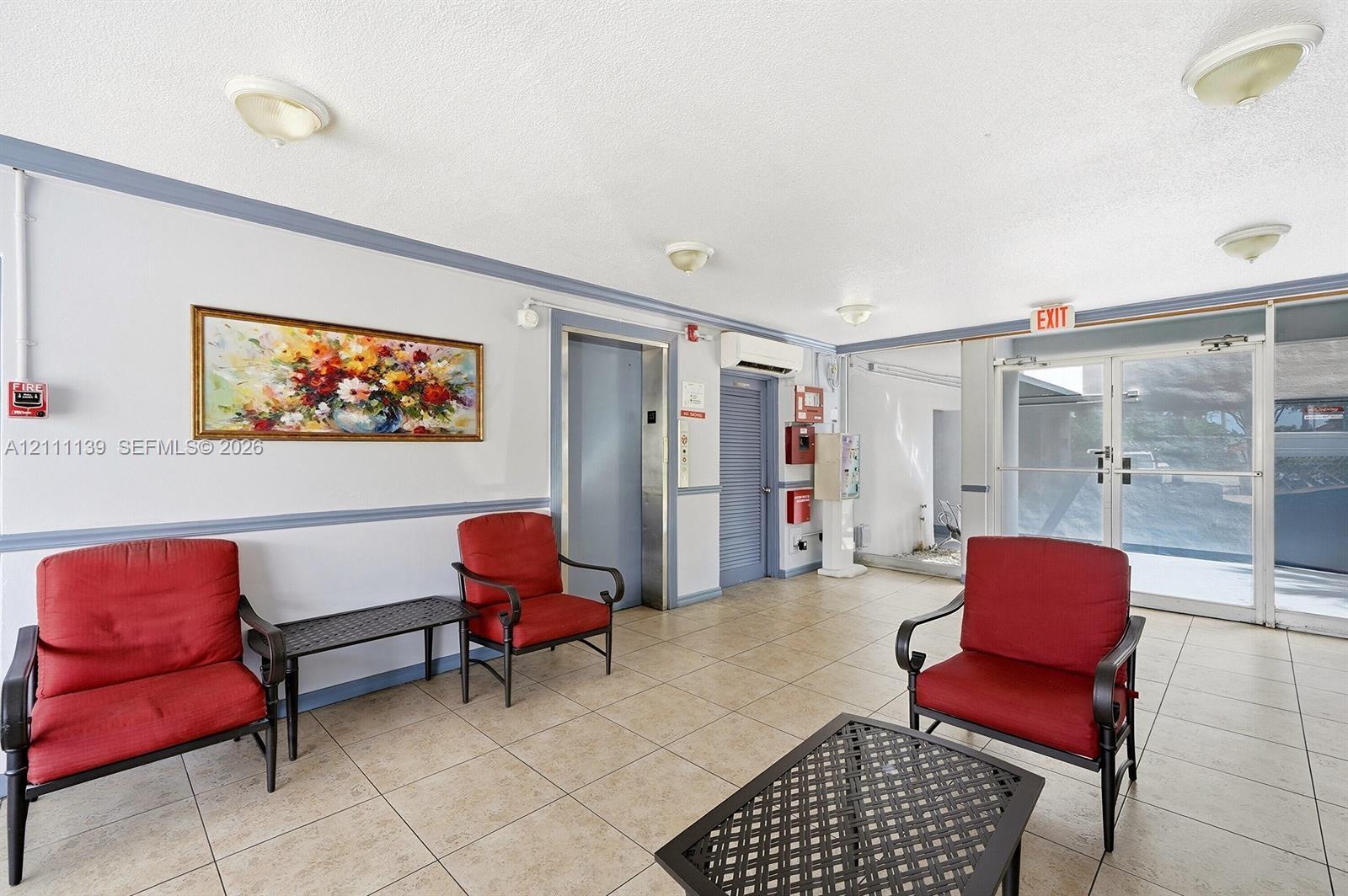 Common area featuring neutral floor tiling, flush-mount ceiling lighting, a dedicated elevator, and a glass-paneled entry door