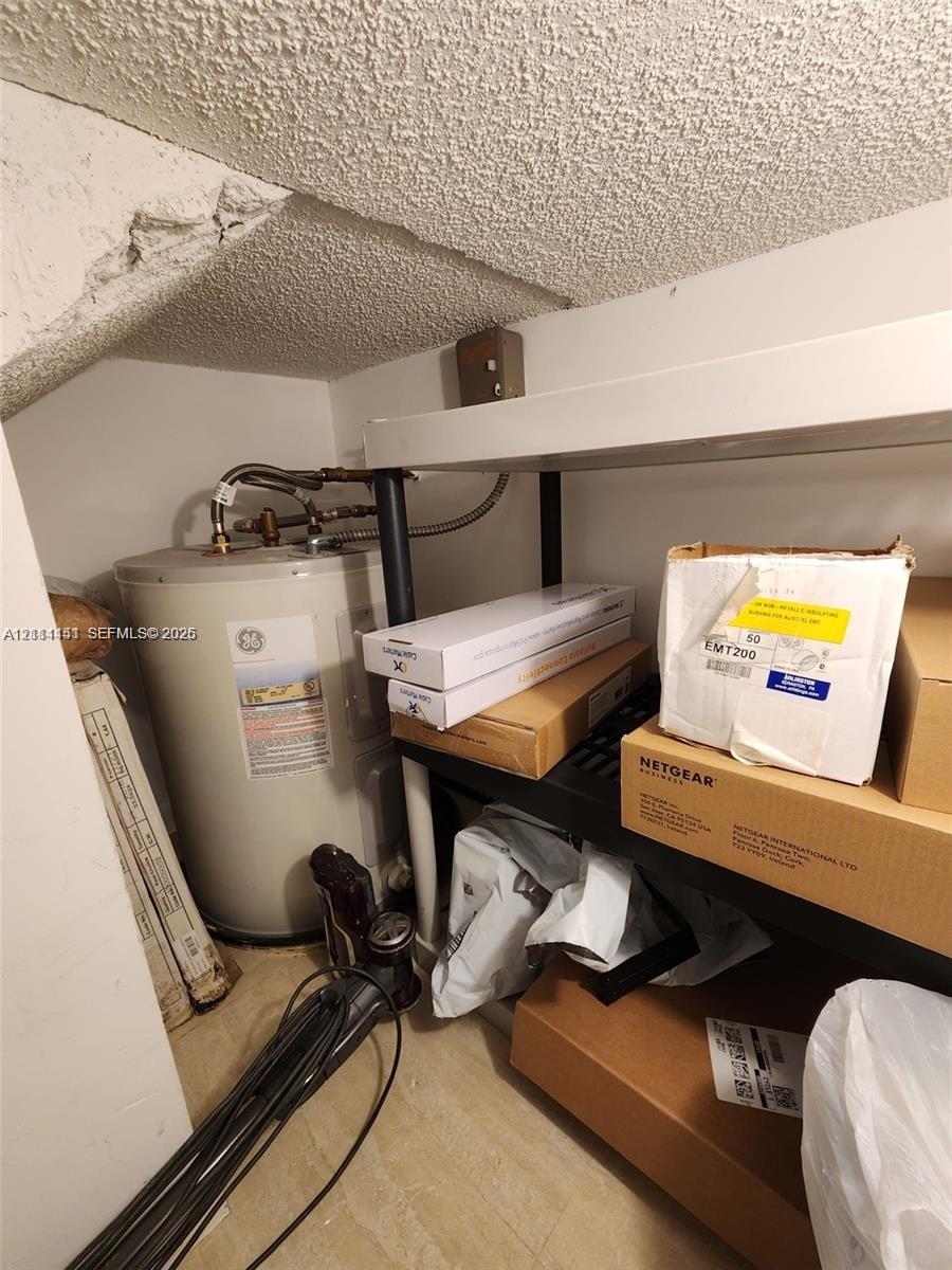 Utility area featuring a water heater and structural ceiling finish