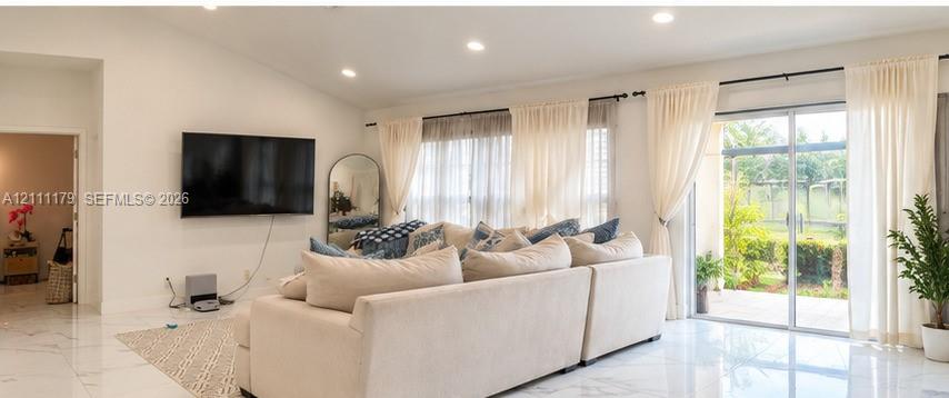 Vaulted ceilings, large-format polished tile flooring, recessed lighting, and expansive glass sliding doors