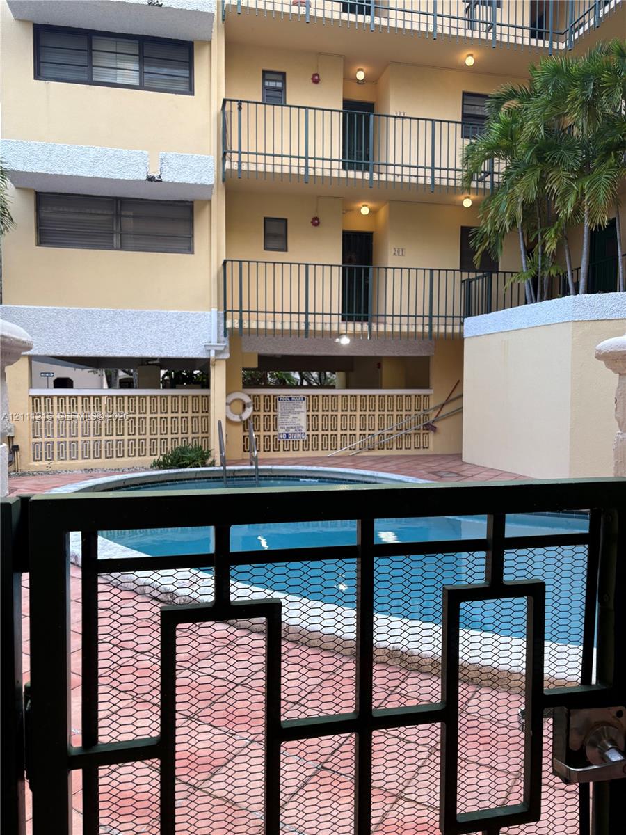 Swimming pool featuring decorative lattice hardscaping, tile decking, and metal balcony railings