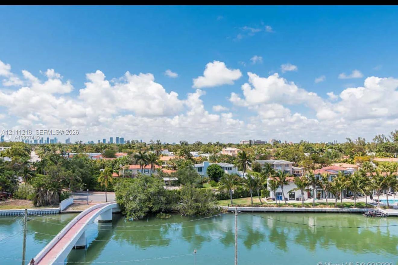Waterfront setting featuring a concrete arch bridge, bulkhead seawall, and tropical vegetation Waterfront setting featuring a concrete arch bridge, bulkhead seawall, and tropical vegetation