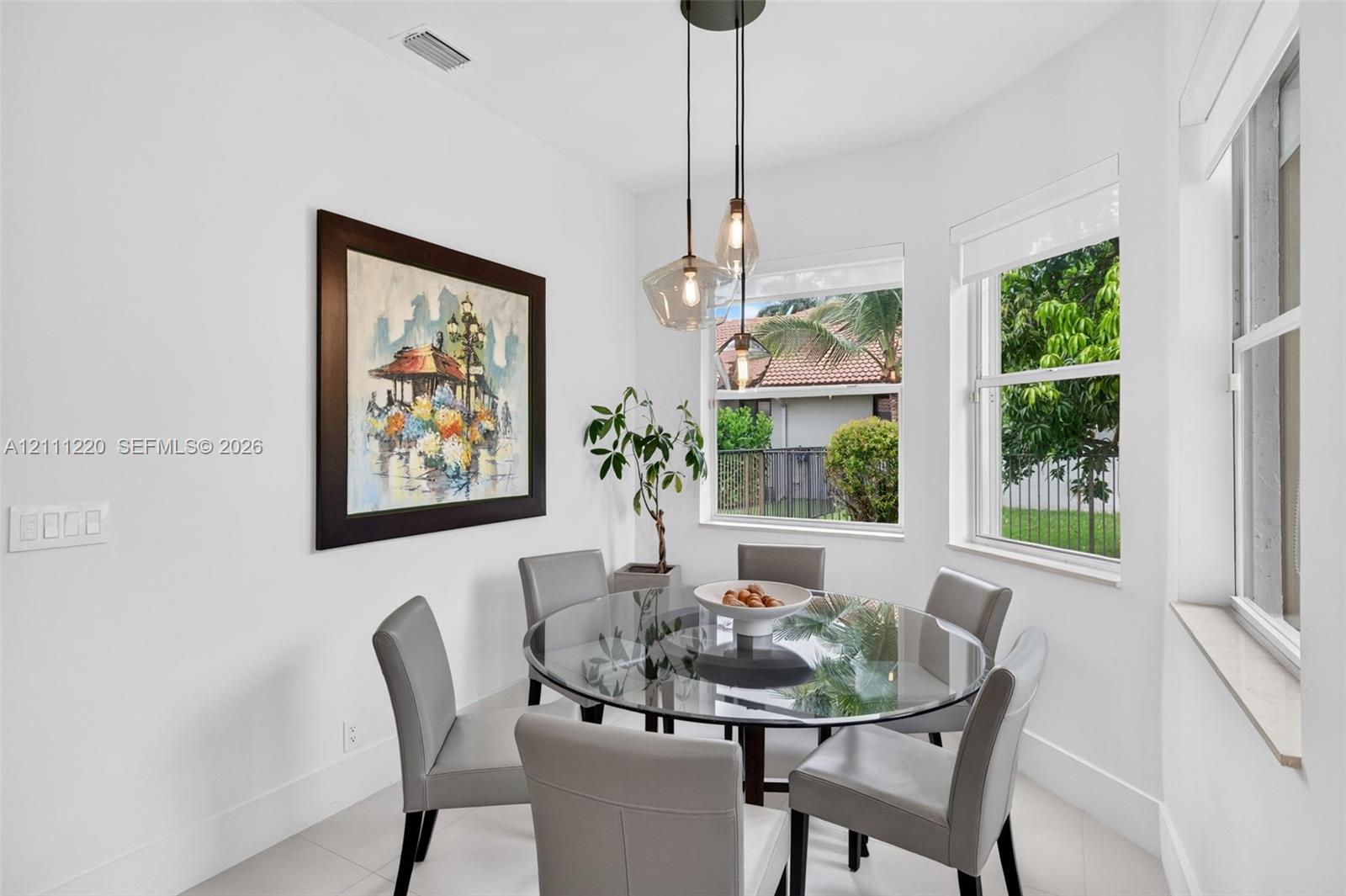 Nook featuring triple-pendant light fixture, large pane windows, and neutral tile flooring