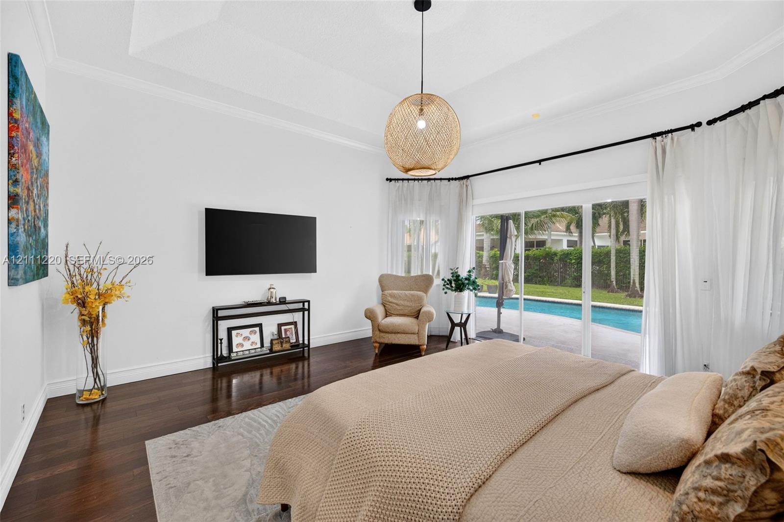 Tray ceiling, dark wood-finish flooring, and woven spherical pendant lighting