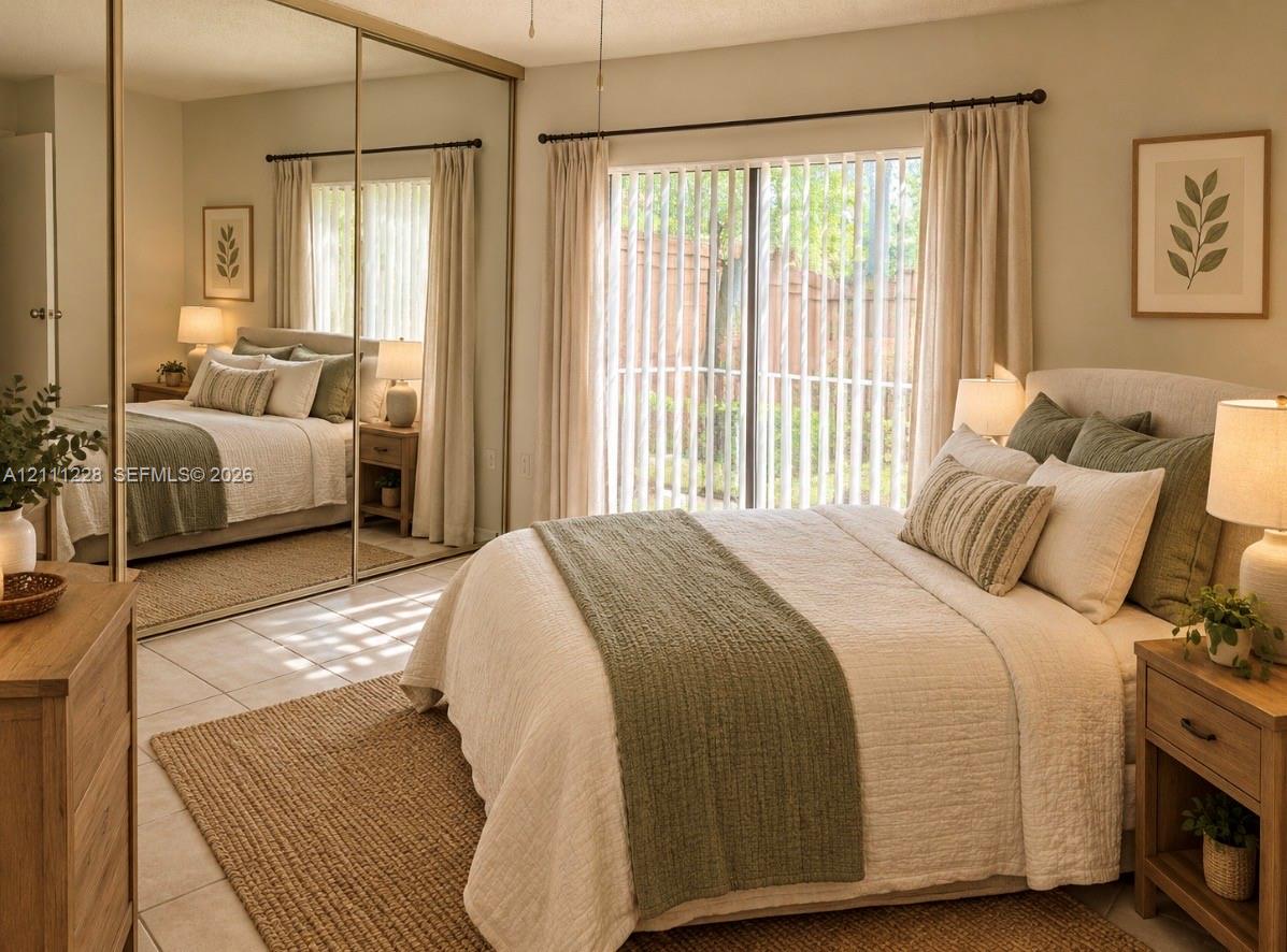 Floor-to-ceiling mirrored closet doors, sliding glass patio door, and neutral tile flooring